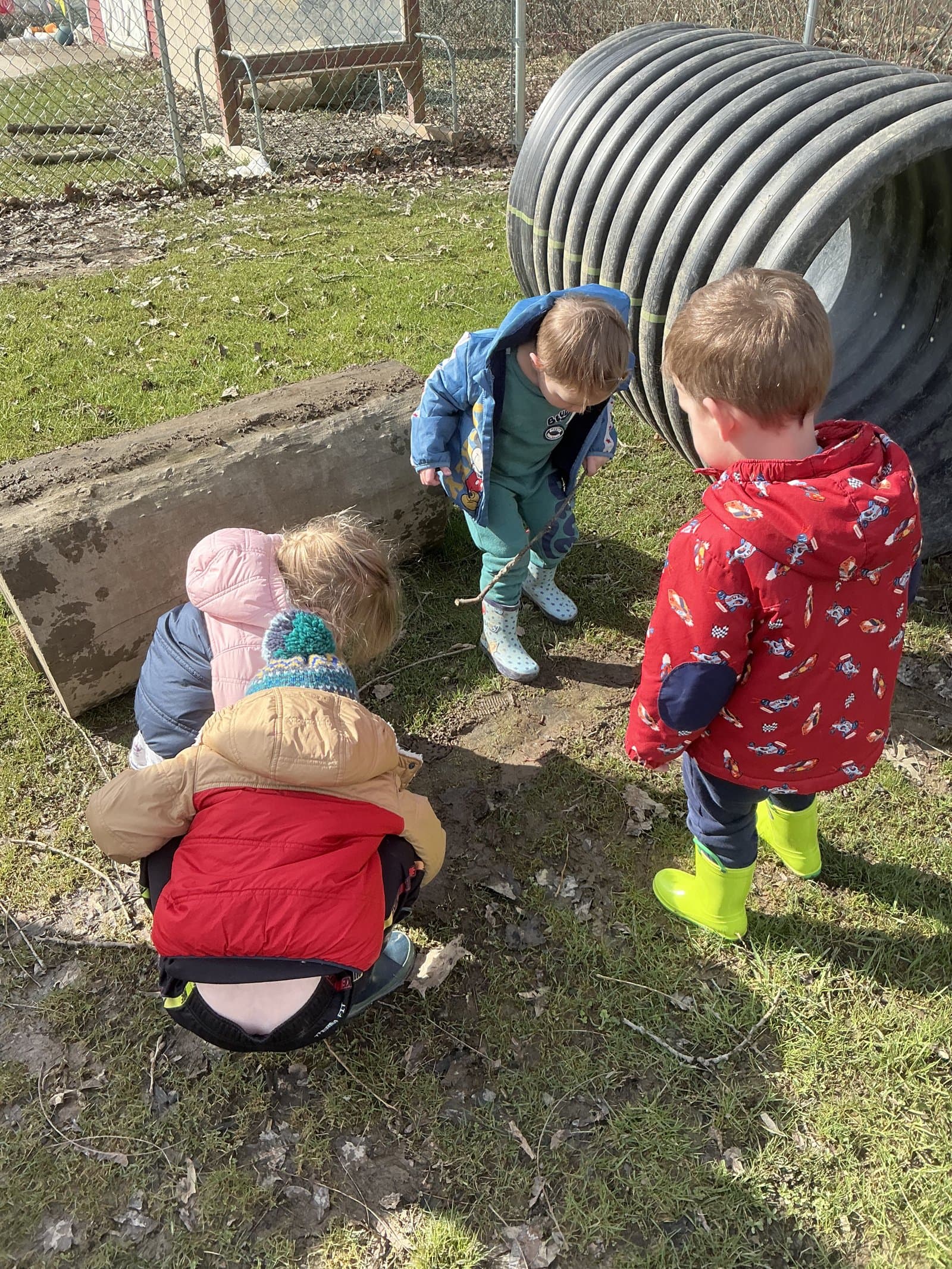 Little Acorns children investigating outdoors on an Erie PA spring day