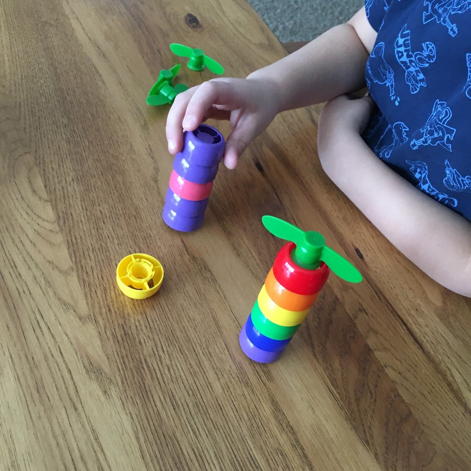 Toddler stacking colorful rainbow rings at Little Acorns Learning Center