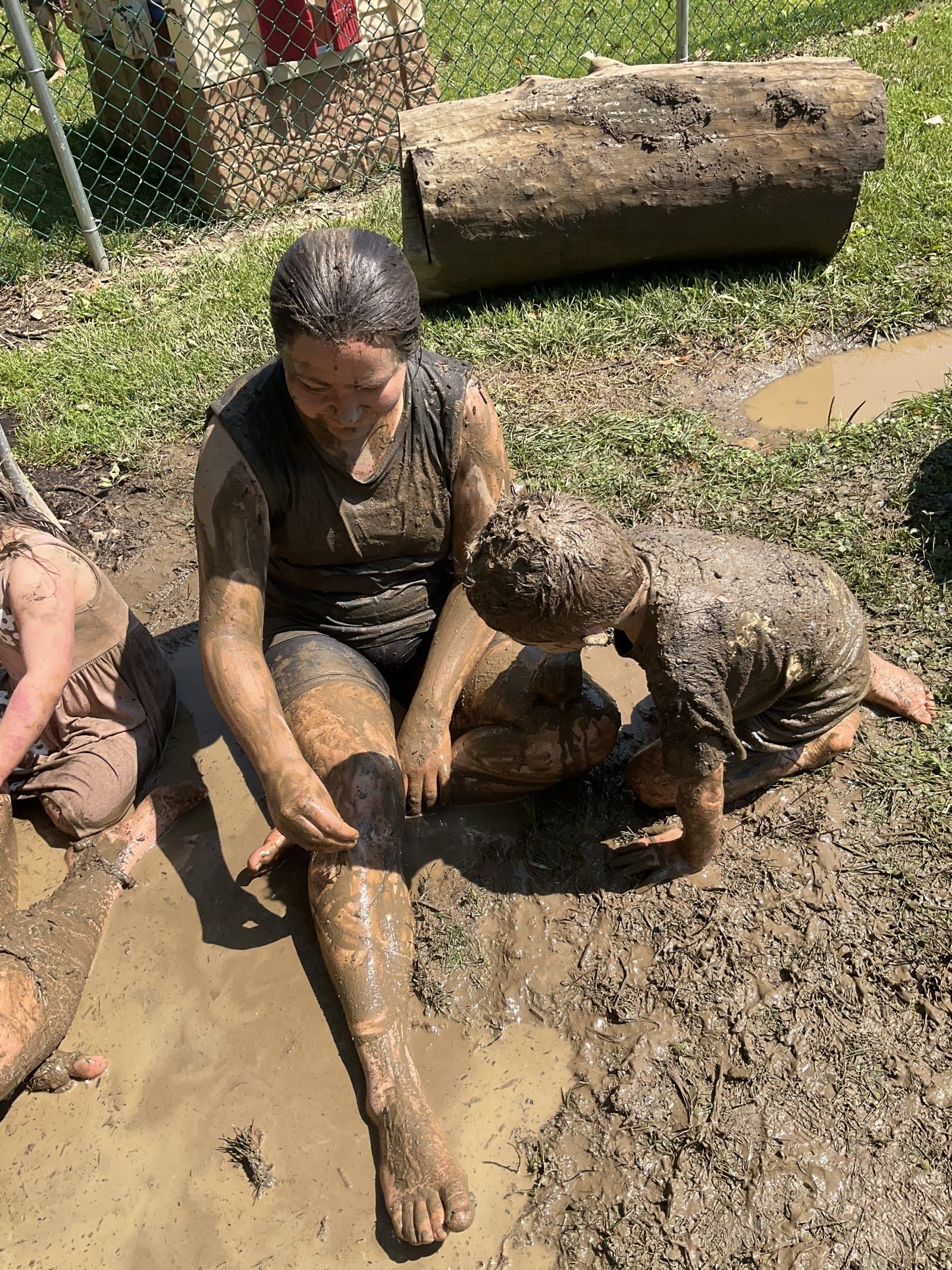 International Mud Day at Little Acorns Learning Center — teacher and child playing in the mud, kids are washable