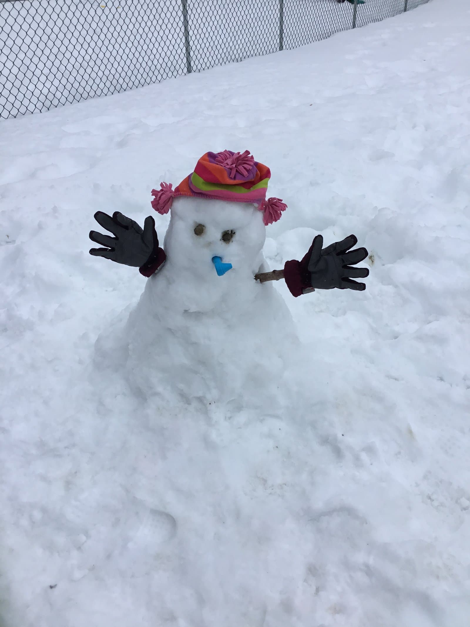 Saplings classroom snowman with a rainbow knit hat — winter outdoor play at Little Acorns