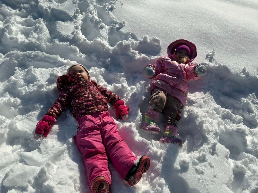 Little Acorns kids making snow angels outside